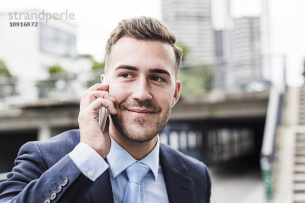 Porträt eines jungen Geschäftsmannes am Telefon