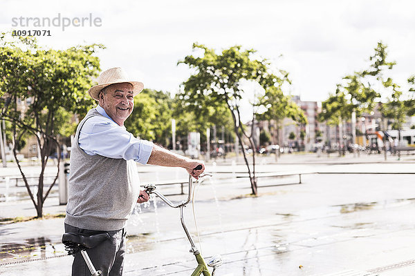Lächelnder älterer Mann mit klappbarem Fahrrad