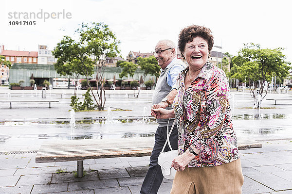 Deutschland  Mannheim  glückliches Seniorenpaar geht Hand in Hand