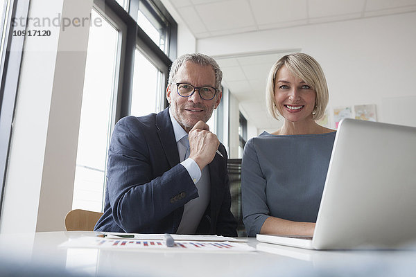 Geschäftsmann und Frau arbeiten zusammen im Büro mit Laptop