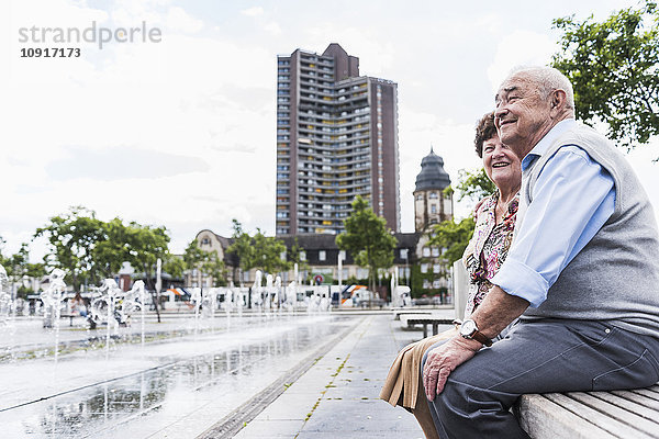 Deutschland  Mannheim  Seniorenpaar auf einer Bank sitzend