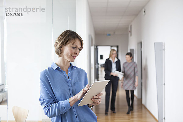 Geschäftsfrau mit digitalem Tablett im Bürogeschoss