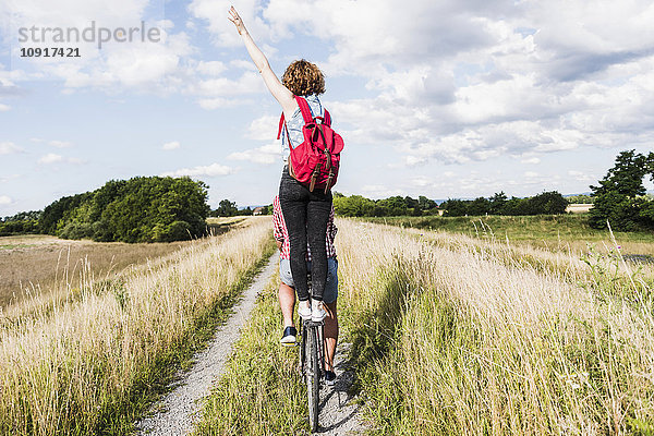 Junge Frau auf Fahrradträger stehend