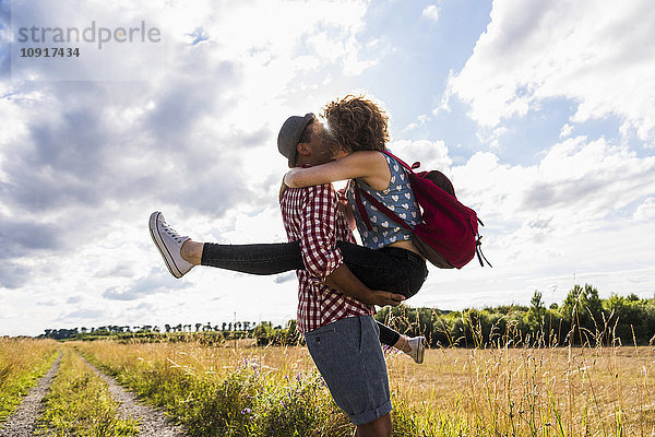 Junges Paar beim Küssen auf dem Feldweg