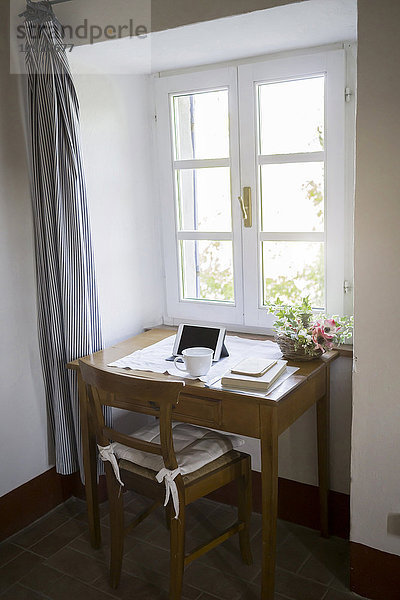 Digitales Tablett  Bücher und Kaffeetasse auf dem Schreibtisch in einem Landhaus