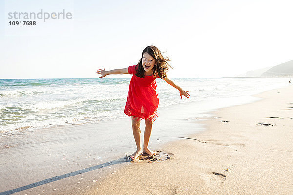 Porträt eines fröhlichen kleinen Mädchens  das am Strand spielt.