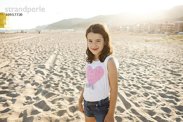 Porträt eines lächelnden kleinen Mädchens am Strand