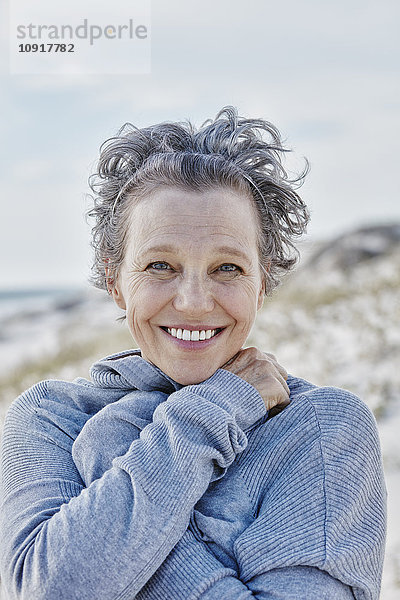 Porträt einer lächelnden Frau am Strand