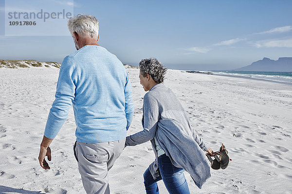 Rückansicht des Paares beim Spaziergang am Strand