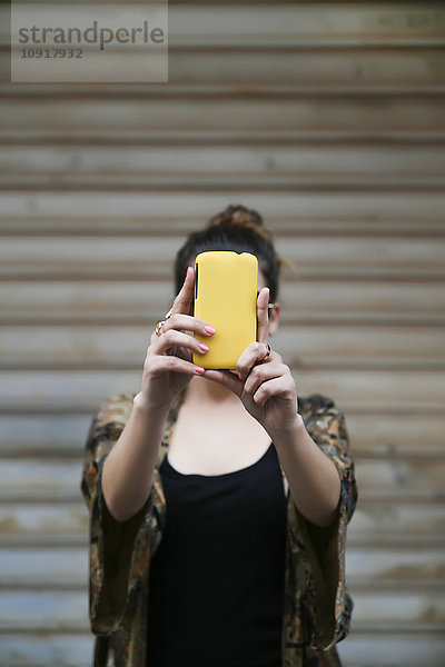 Junge Frau  die einen Selfie mit Smartphone nimmt