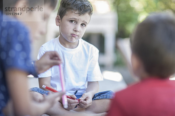 Trauriger kleiner Junge mit seinen Freunden