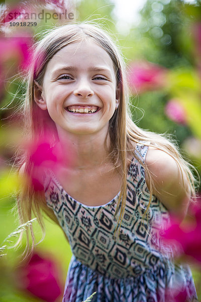 Porträt des glücklichen Mädchens mit Zahnlücke im Garten