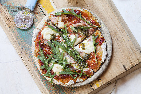 Hausgemachte glutenfreie Pizza mit Mozzarella  Rucola-Pesto und frischer Rucola