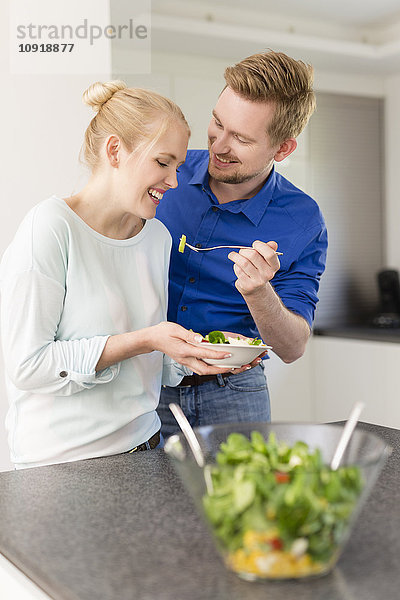 Glückliches Paar in der Küche mit Salat