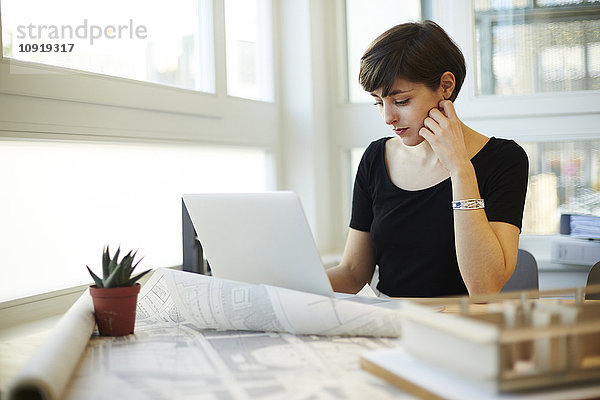 Portrait der Architektin mit Laptop in ihrem Büro