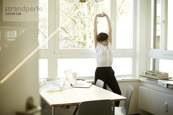 Frau beim Stretching in ihrem Büro