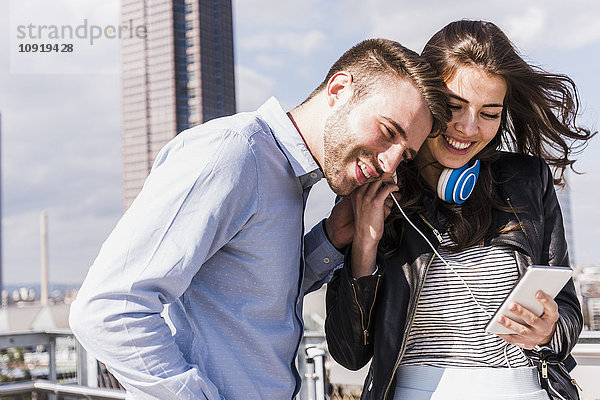 Glückliches junges Paar beim Musikhören