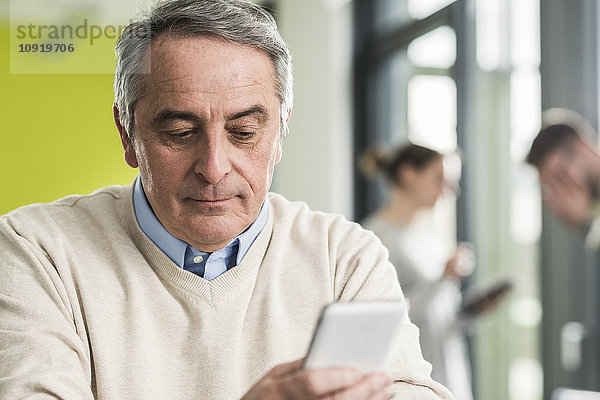 Senior Manager beim Lesen einer Nachricht  Smartphone