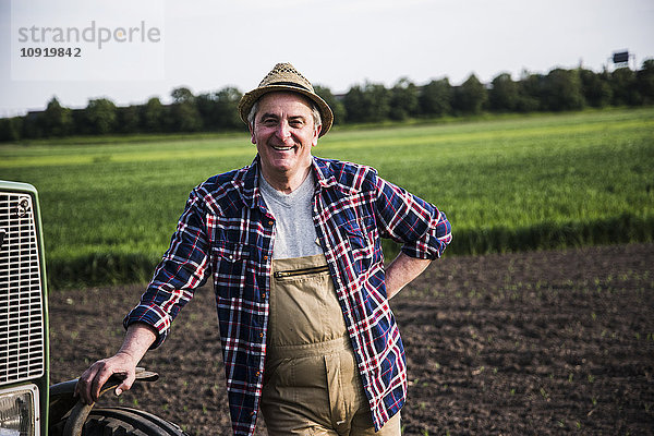 Porträt eines lächelnden Bauern vor einem Feld