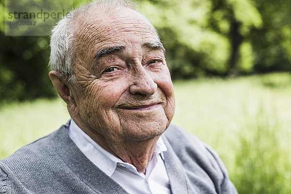 Porträt eines lächelnden Senioren in der Natur