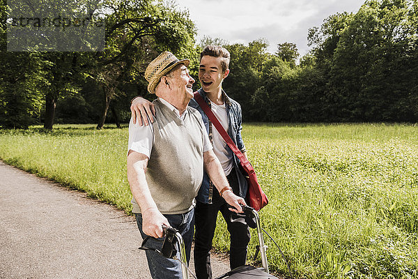 Glücklicher Großvater  der mit seinem Enkel in der Natur spazieren geht.