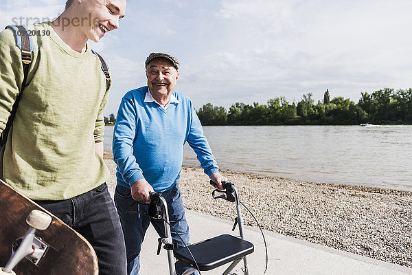 Großvater und Enkel beim gemeinsamen Spaziergang am Flussufer