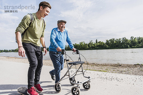 Großvater und Enkel beim gemeinsamen Spaziergang am Flussufer