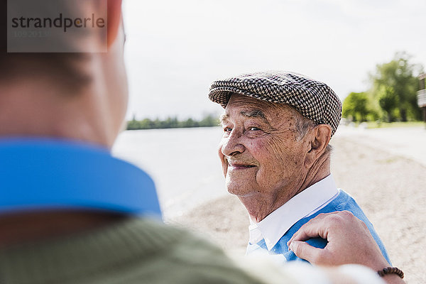 Porträt eines lächelnden älteren Mannes  der seinen Enkel ansieht.