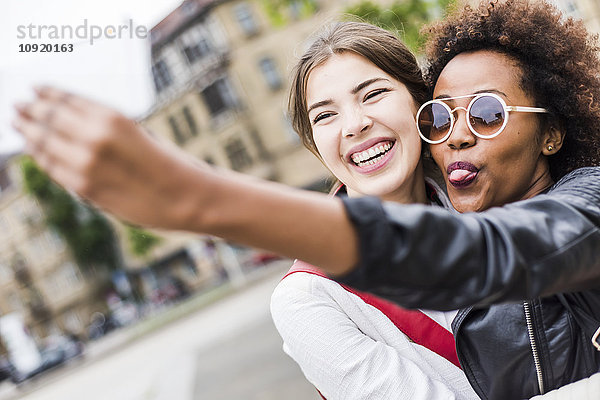 Porträt von zwei glücklichen besten Freunden  die Selfie mit dem Smartphone nehmen.