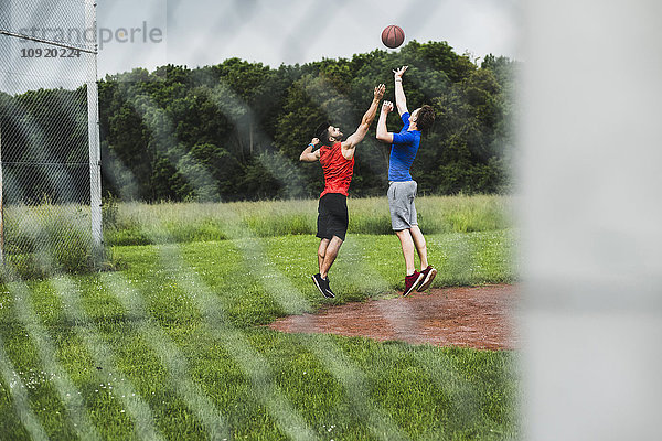 Zwei Männer spielen Basketball im Freien