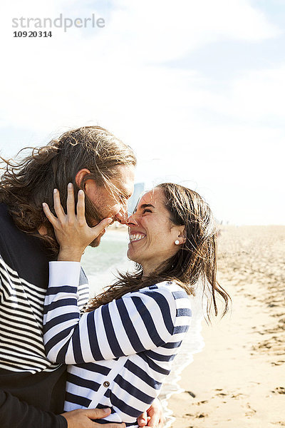 Spanien  Barcelona  glückliches Paar  das sich am Strand die Nase reibt
