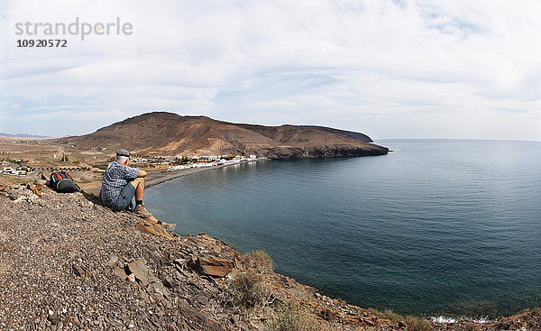 Spanien  Kanarische Inseln  Fuerteventura  Südostküste  Giniginamar  Wanderer mit Blick auf den Berg Lapa