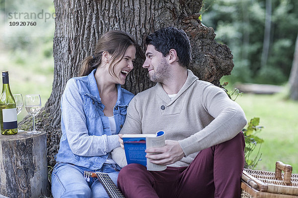 Glückliches junges Paar beim Picknick mit Weißwein