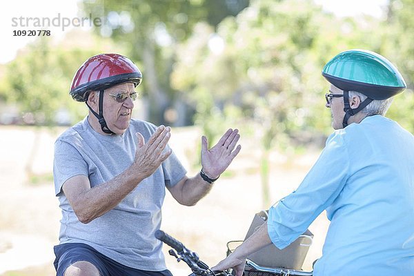 Ältere Paare auf Fahrrädern im Gespräch