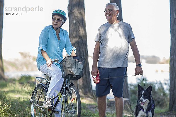 Älteres Paar mit Hund und Fahrrad im Wald