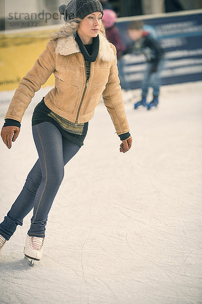 Junge Frau beim Schlittschuhlaufen auf der Natureisbahn