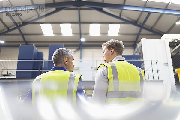 Supervisor und Arbeiter im Gespräch im Stahlwerk