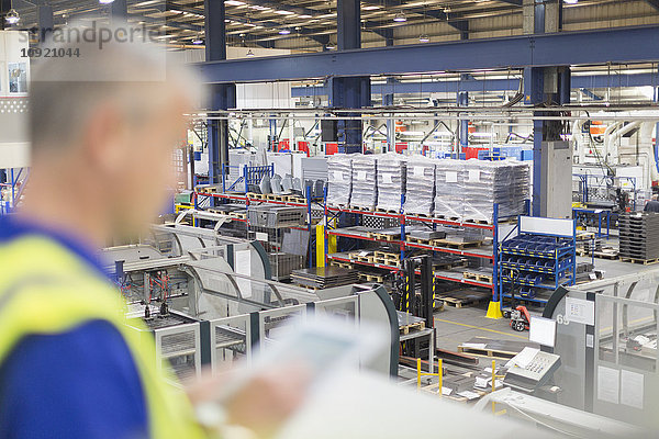 Supervisor mit digitalem Tablett mit Blick auf die Stahlfabrik