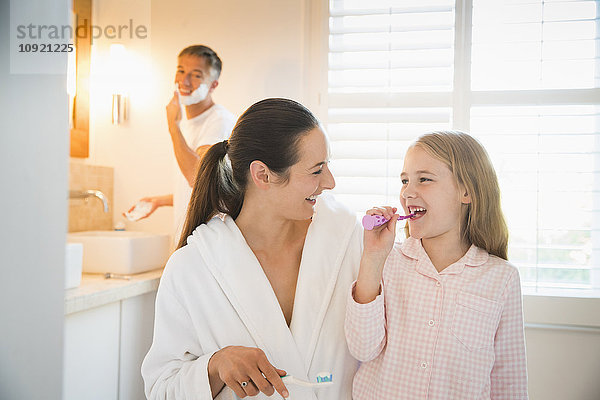 Mutter und Tochter beim Zähneputzen im Bad