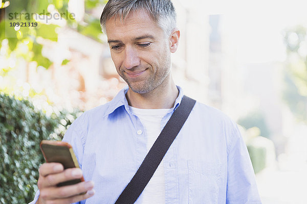 Geschäftsmann texting mit Handy im Freien