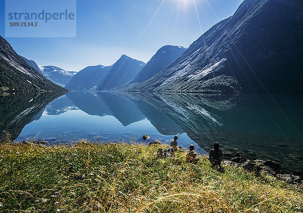 Freunde entspannen sich am sonnigen  ruhigen Bergseeufer  Norwegen