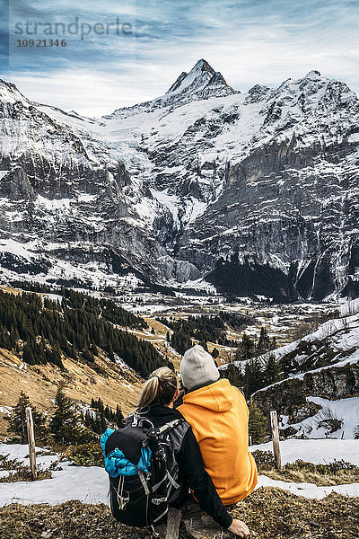 Paar mit Blick auf die verschneite Bergwelt  Grindelwald  Schweiz