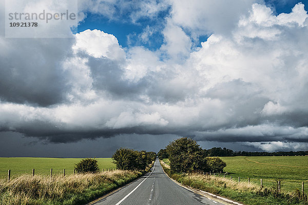 Flauschige Wolken über Land und Landstraße