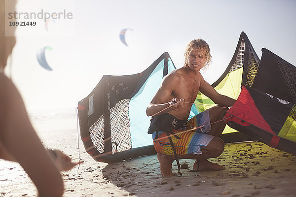 Mann bereitet Kitekite am sonnigen Strand vor