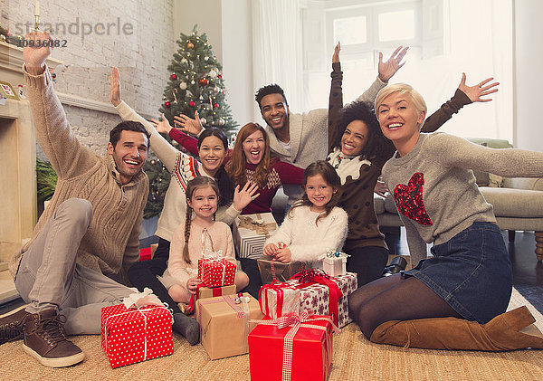 Portrait begeisterte Familie und Freunde mit Weihnachtsgeschenken im Wohnzimmer