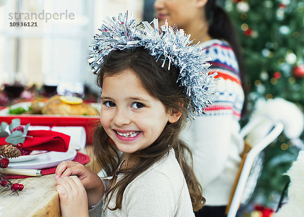 Portrait begeistertes Mädchen mit Kranz beim Weihnachtsessen