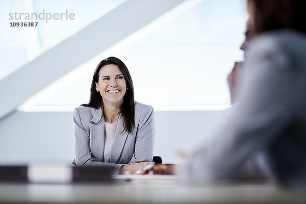 Lächelnde Geschäftsfrau beim Zuhören im Meeting
