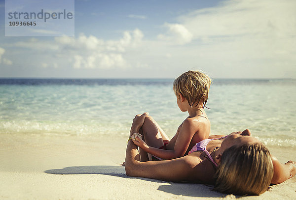 Mutter und Sohn liegen und entspannen am tropischen Strand