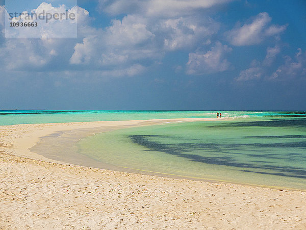 Menschen in der Ferne  die am tropischen Strand spazieren gehen  Malediven