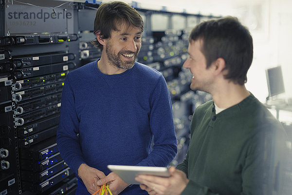 Techniker im Serverraum mit digitalem Tablet
